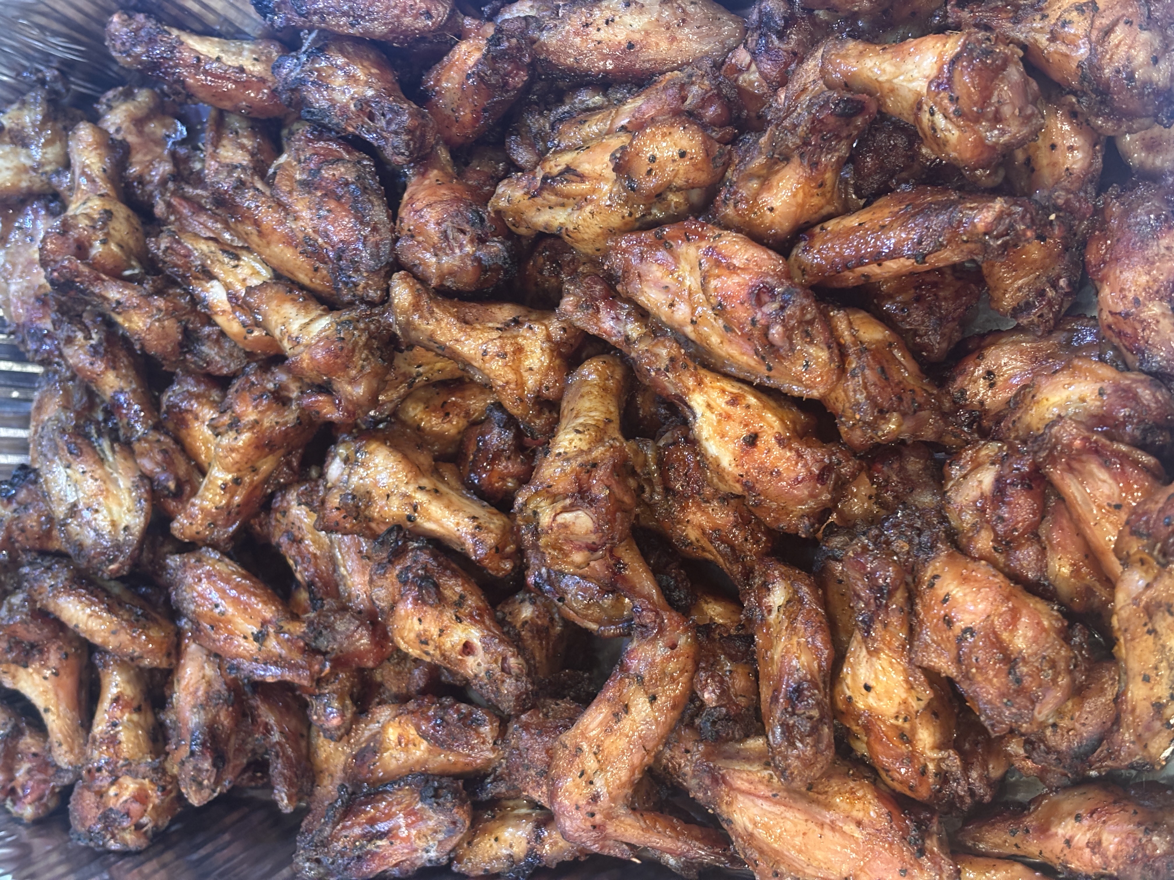 Overflowing pan of smoked chicken wings