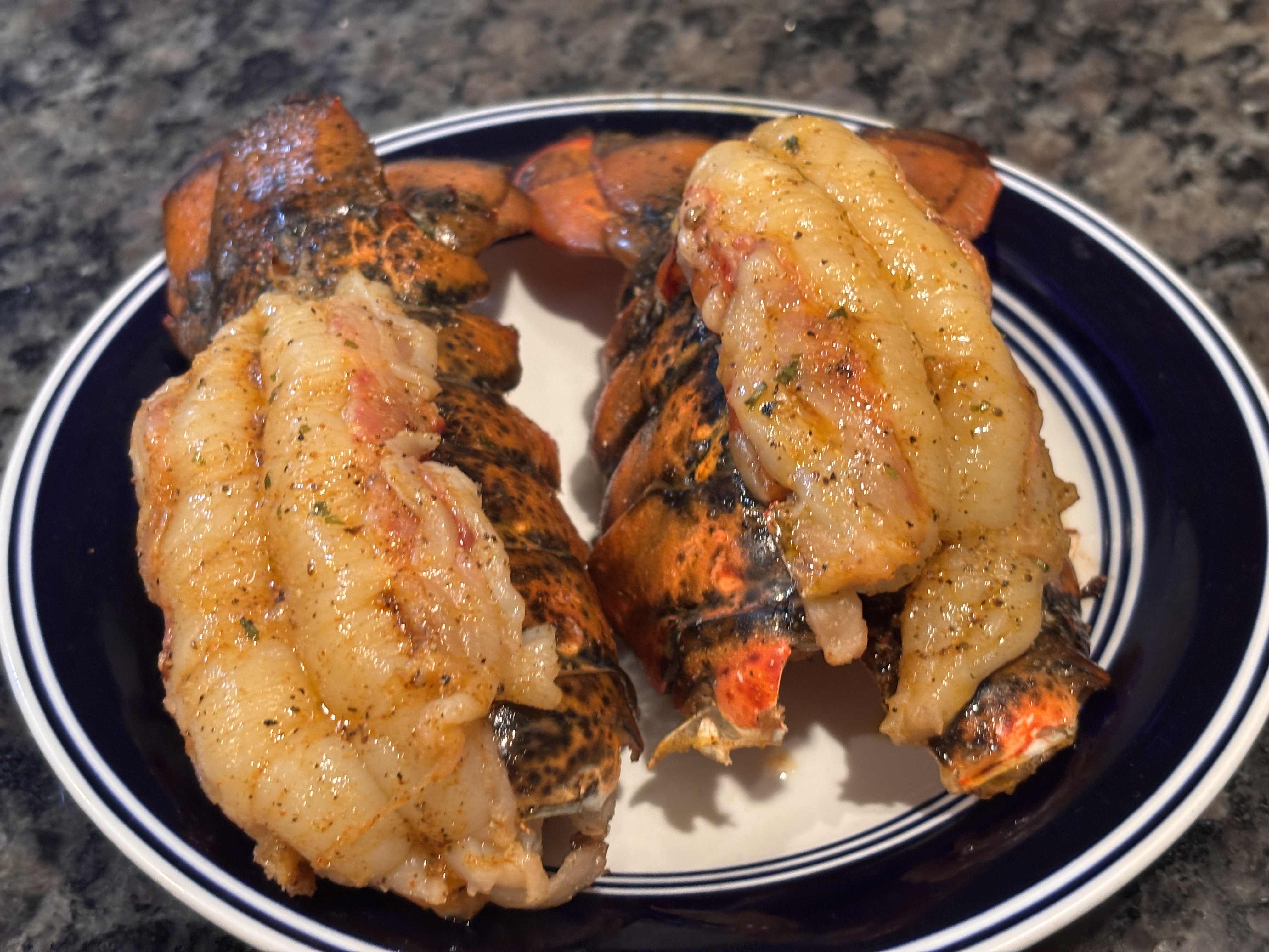 Two seasoned lobster tails on a plate