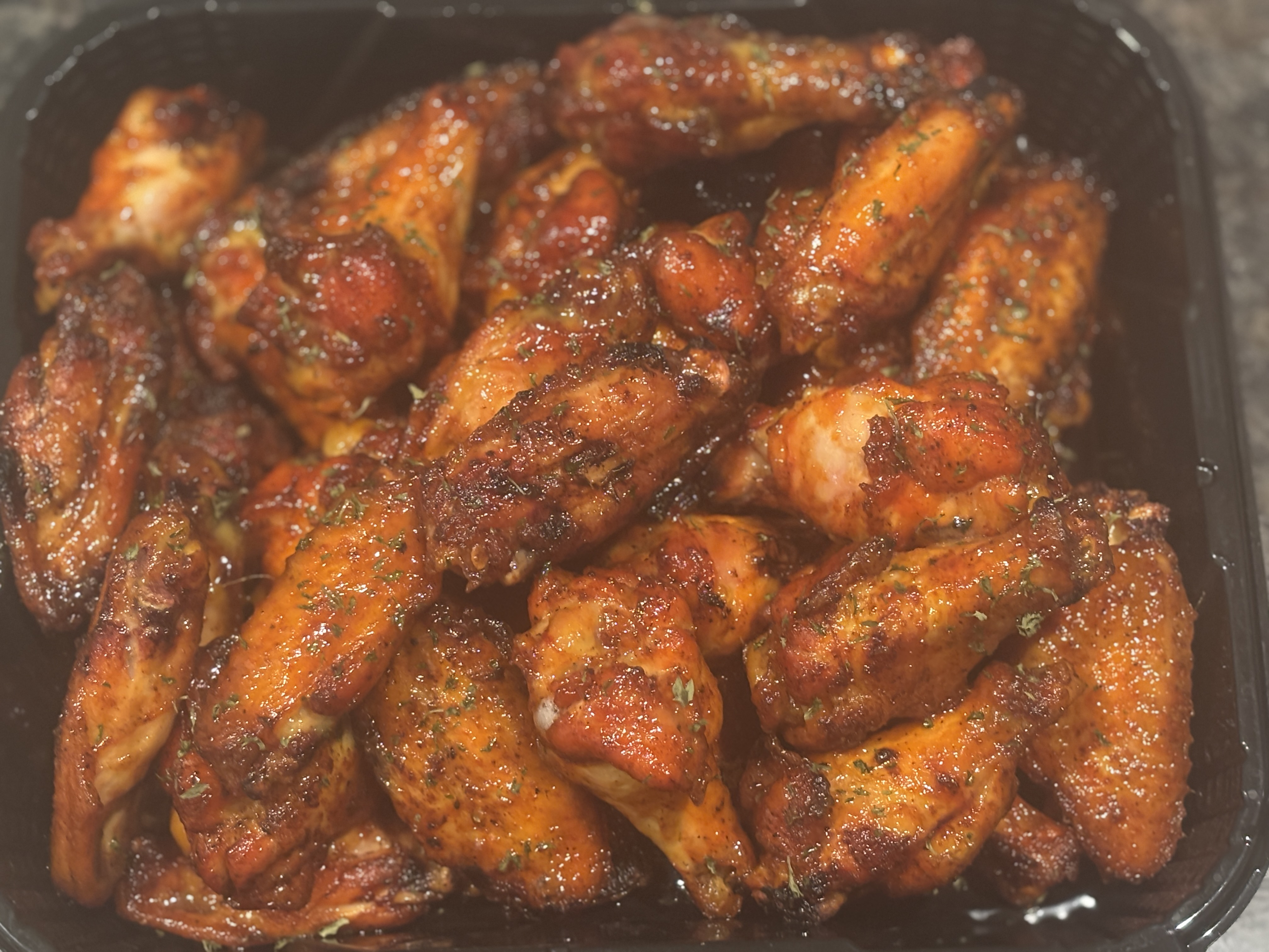 Hot honey glazed chicken wings in a to-go tray