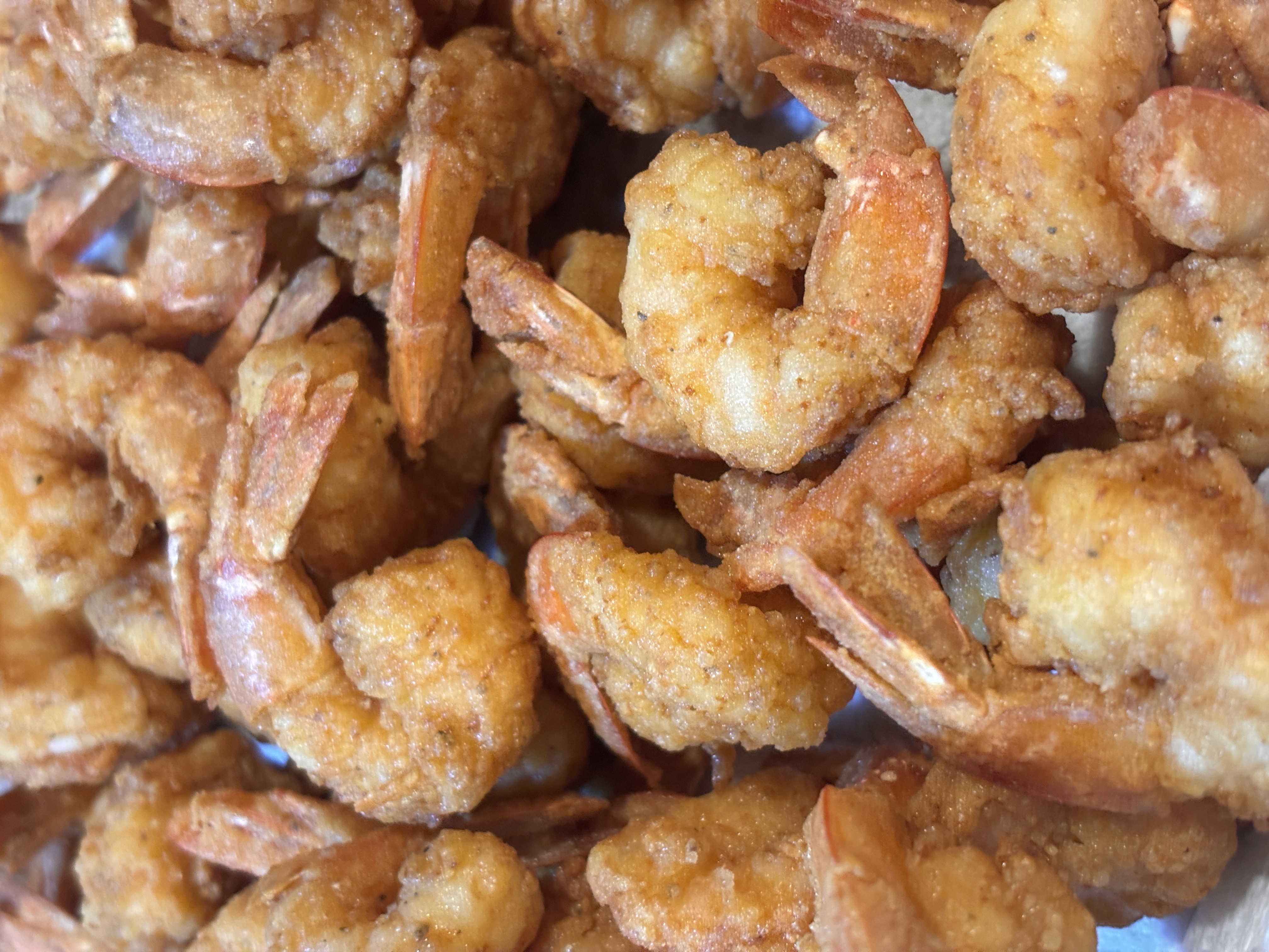Golden fried shrimp piled on a plate